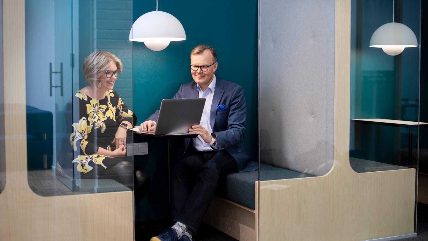 En man och en kvinna som tillsammans tittar på en dataskärm och ler.